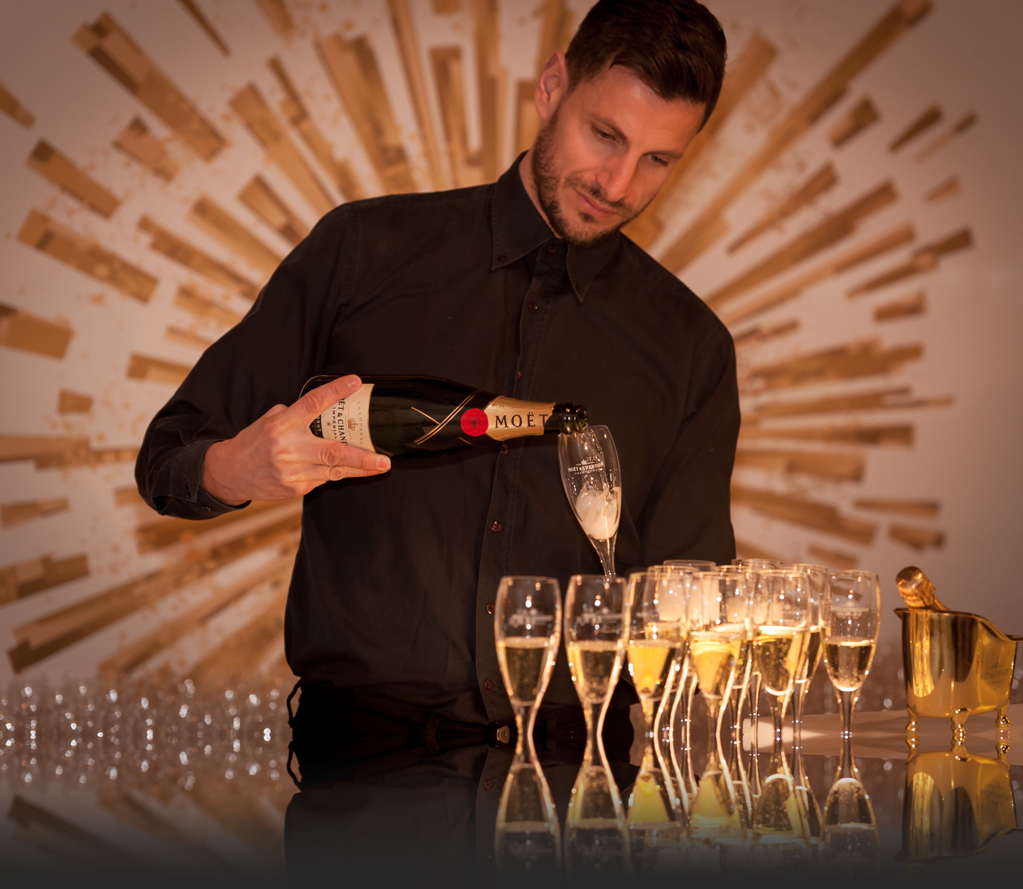 Bartender pouring champagne at an elegant event, illustrating premium hospitality and attentive service.