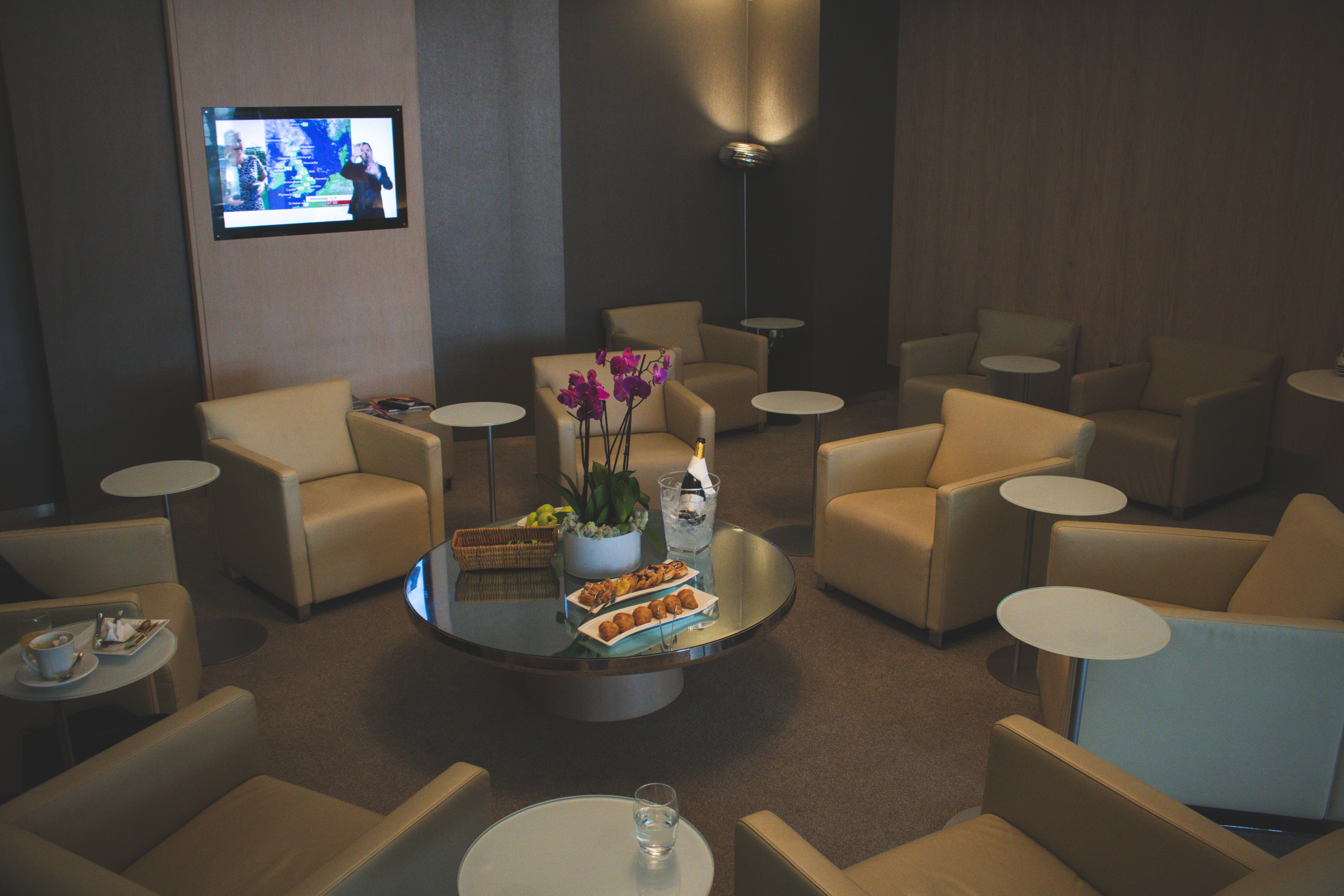 Elegant airport lounge with comfortable seating and refined decor, showing the comfort and convenience of premium travel.