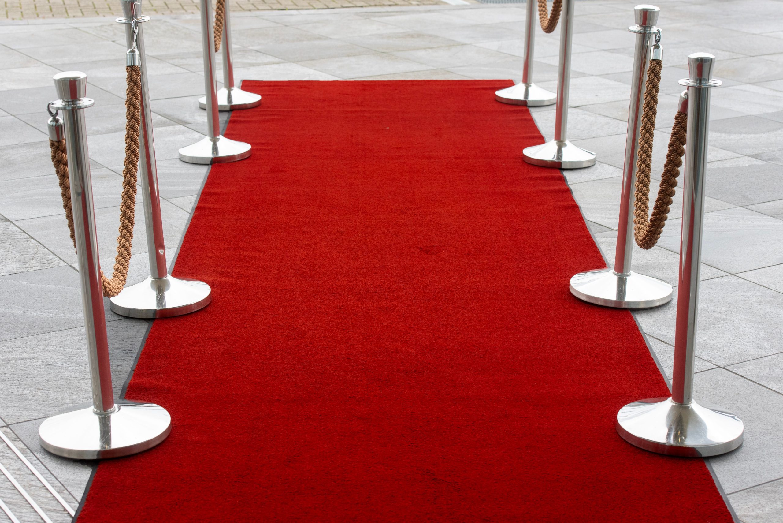 Red carpet entrance with stanchions creating an exclusive VIP event arrival.